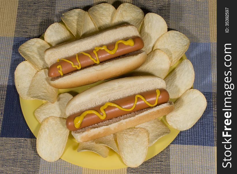 Hot dogs on a plate with chips