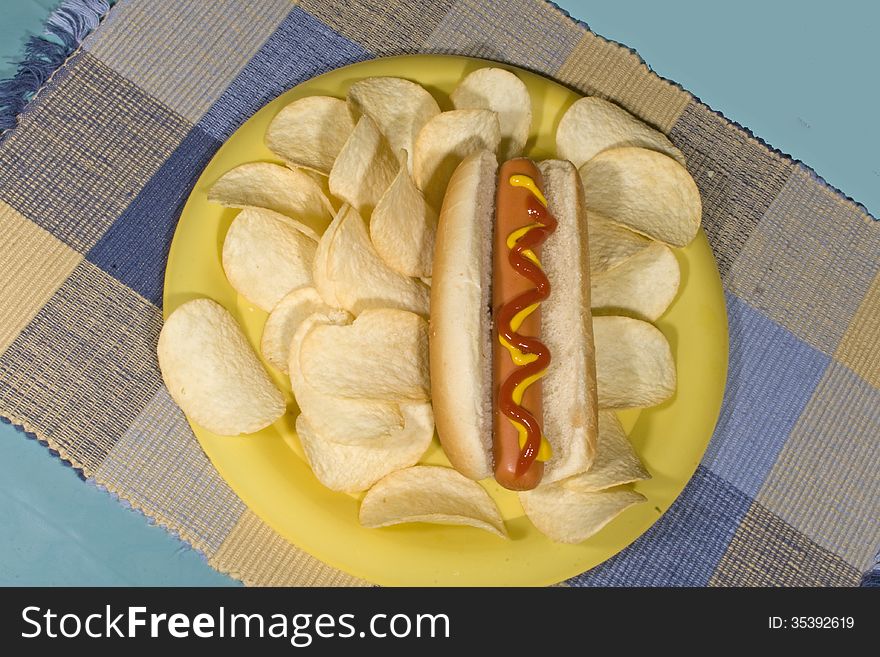 Hot dogs on a plate with chips