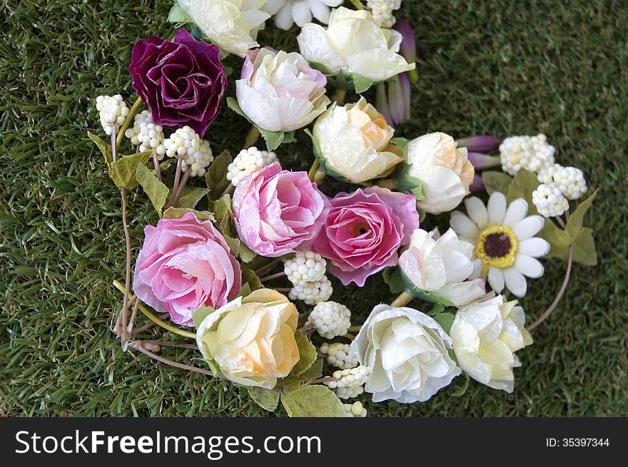 Close up flowers in heart shape on green grass. Close up flowers in heart shape on green grass