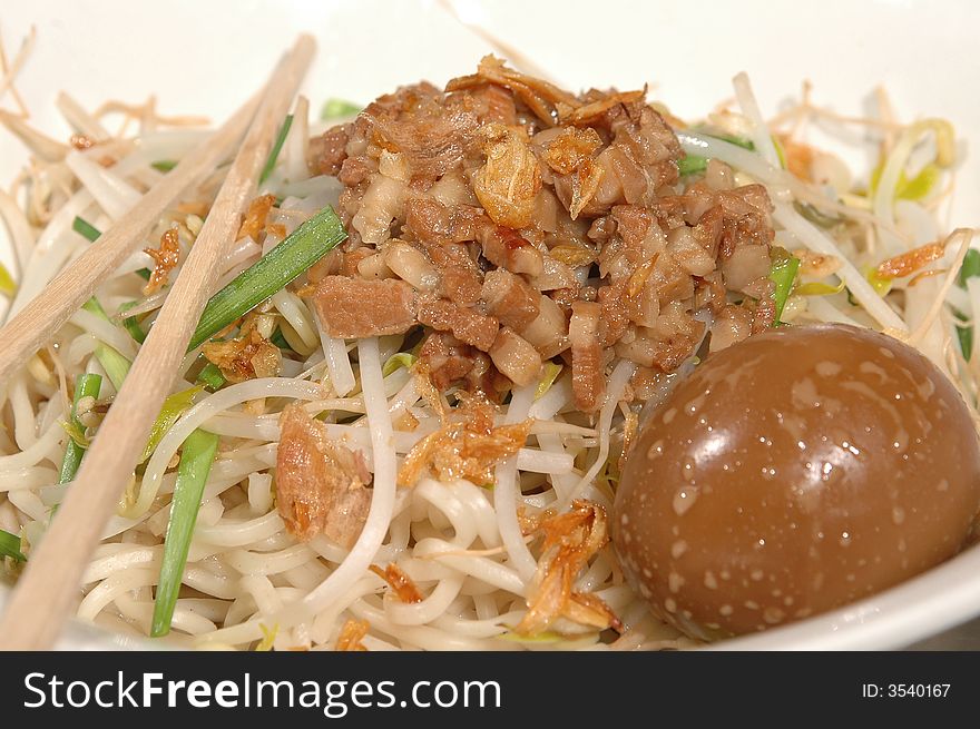 Asian noodle bowl with chopped pork and an egg