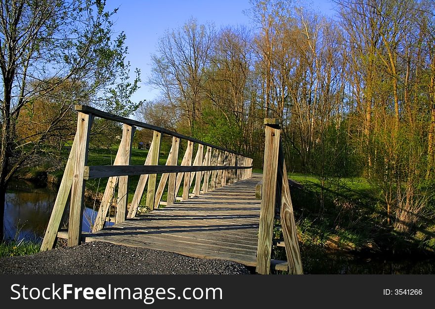 Bridge crossing a lake surrounded by trees with coloured autumn foliage. Bridge crossing a lake surrounded by trees with coloured autumn foliage