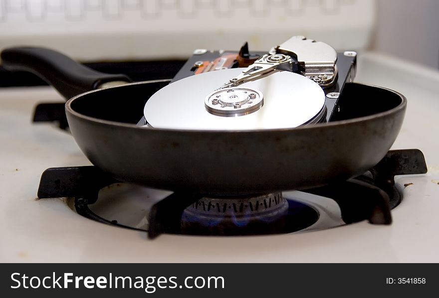 An exposed hard drive in a frying pan on a stove burner. A fried hard drive!