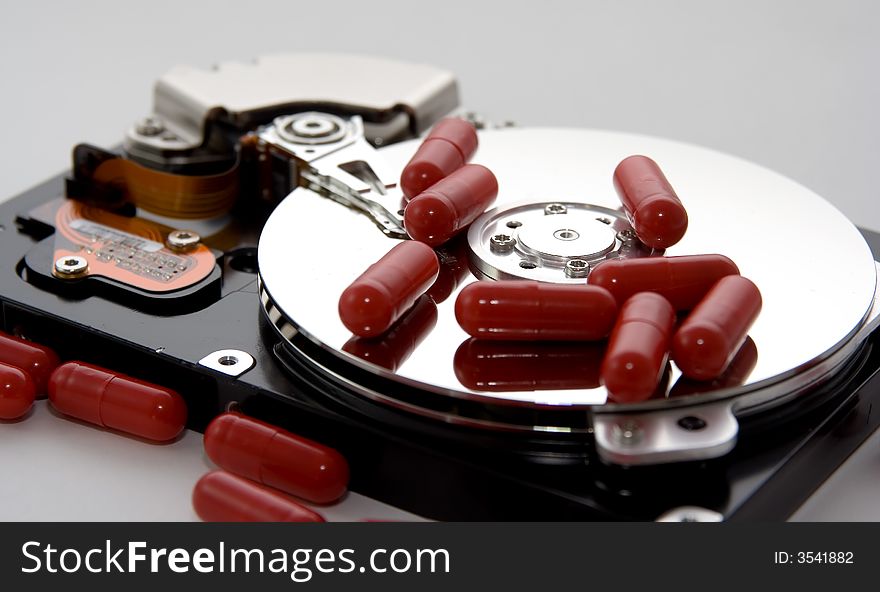 An exposed hard drive with some red capsules / pills. A remedy or fix for the drive!. An exposed hard drive with some red capsules / pills. A remedy or fix for the drive!