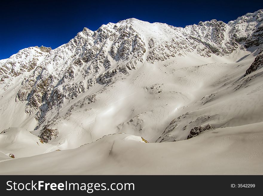 Snow covered mountains under blue sky. Snow covered mountains under blue sky.