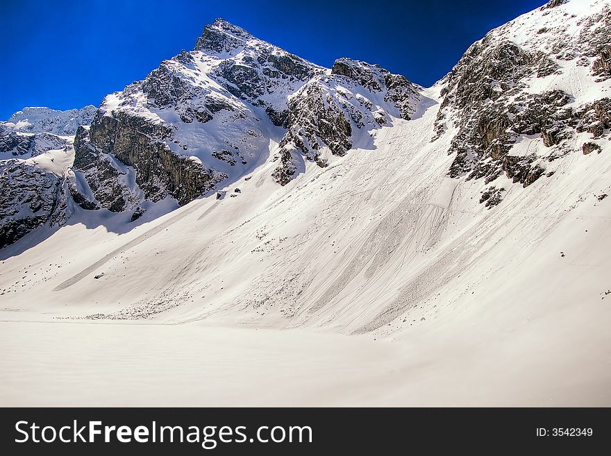 Snow covered mountains under blue sky. Snow covered mountains under blue sky.
