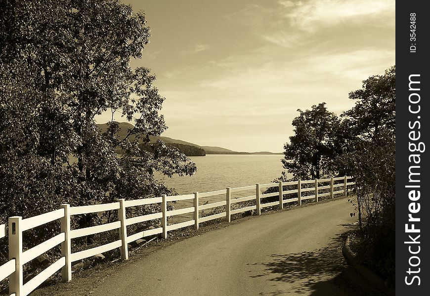 Fence on a dirt road along a lake. Fence on a dirt road along a lake