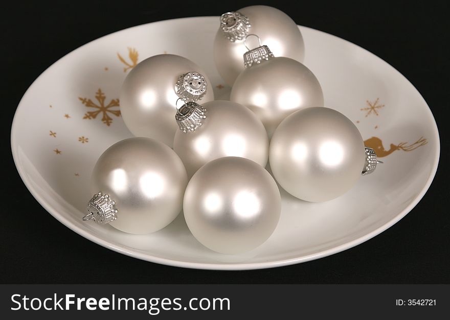 Silver Christmas ornaments on festive plate