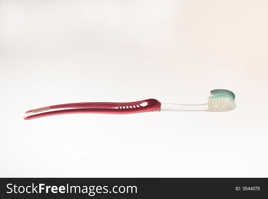 Plastic tooth-brush with the red handle and transparent inserts