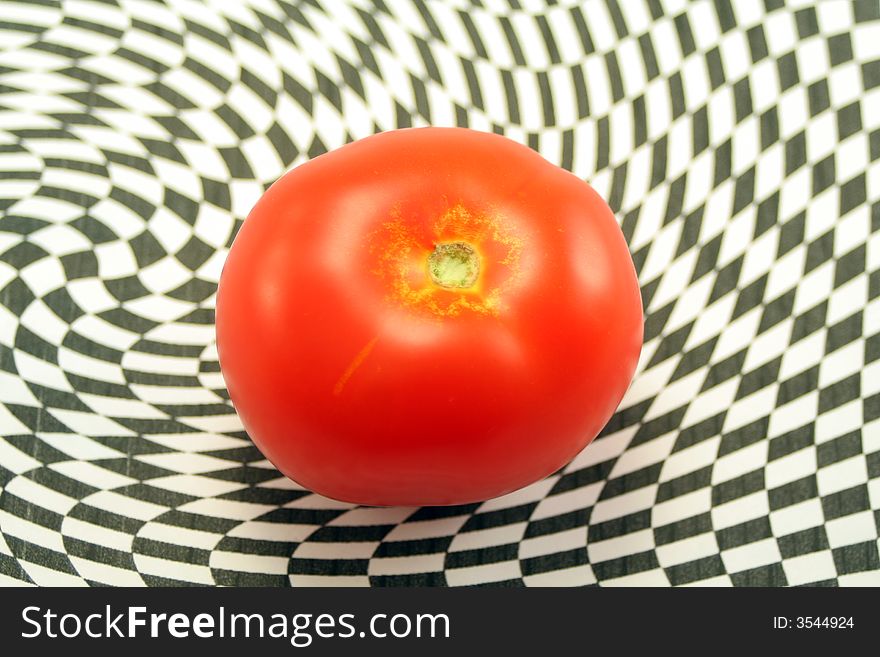 A ripe red tomato on an abstract black and white background