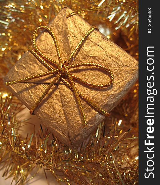 Golden christmas gift box on golden glare background