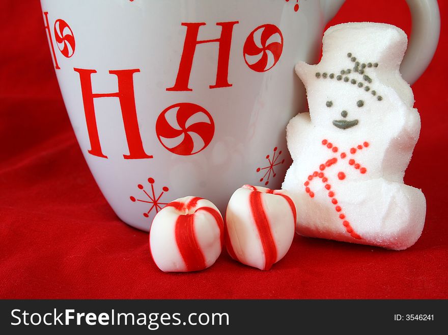 Coffee mug with peppermint candy and snowman on a red background. Coffee mug with peppermint candy and snowman on a red background.