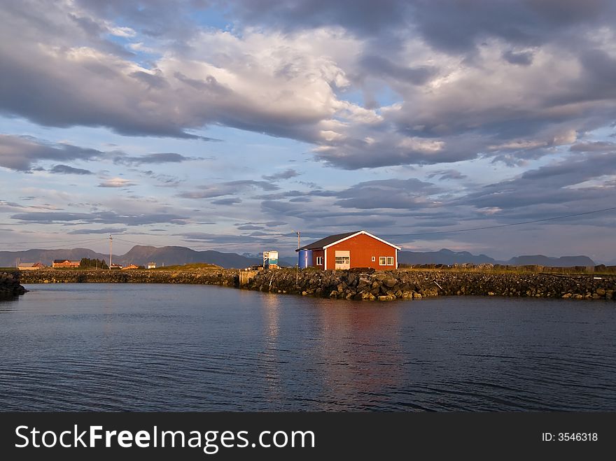 Isolated warehouse on the seashore under cloudy skies