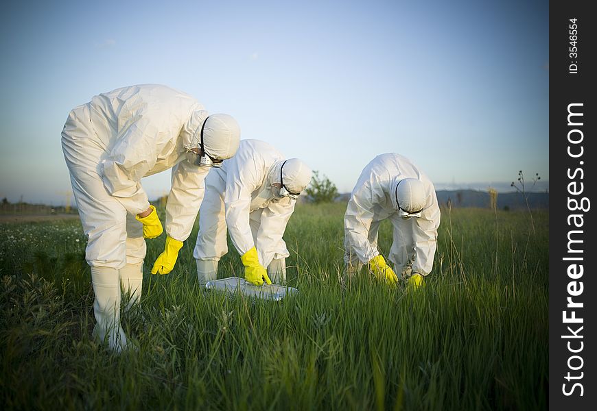 Three people with masks in the field. Three people with masks in the field