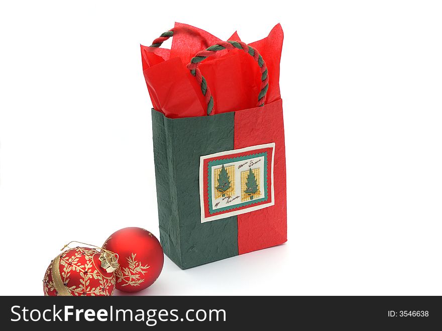 Christmas gift bag and glass balls on white background