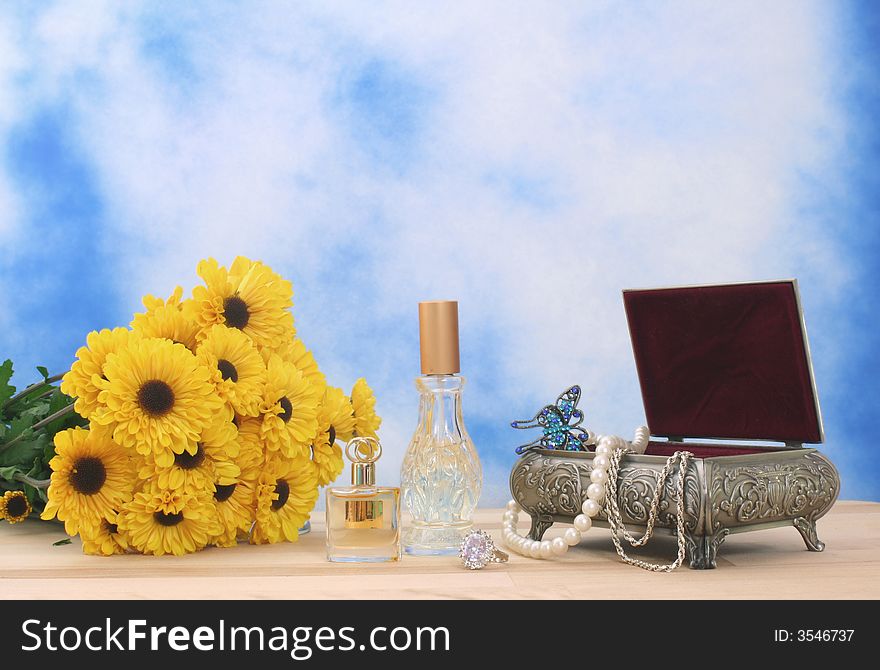 Jewelry Box With Perfume and Flowers With Blue Sky Background. Jewelry Box With Perfume and Flowers With Blue Sky Background