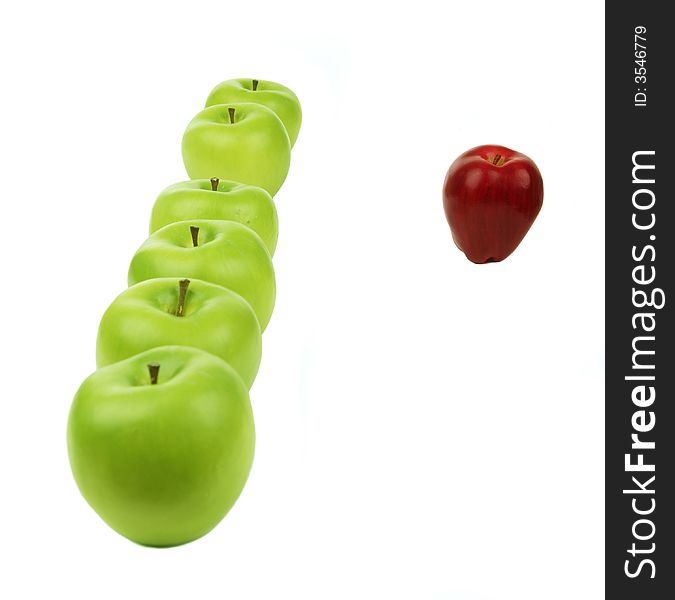 A vertical line of green apples and a red apple sit in the front of them. A vertical line of green apples and a red apple sit in the front of them