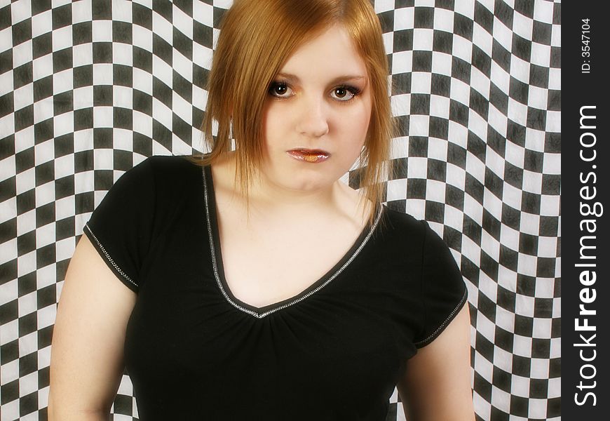 Teen girl against black and white checkered background. Teen girl against black and white checkered background.