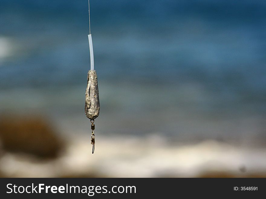 An image of a fishinh hook by the sea. An image of a fishinh hook by the sea.