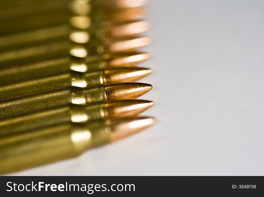 Row of rifle rounds on white sharp focus going to a nice blur. Row of rifle rounds on white sharp focus going to a nice blur