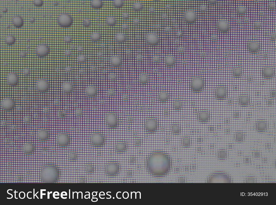 Water droplets refract light from computer screen and reflact ambient light producing interesting patterns. Water droplets refract light from computer screen and reflact ambient light producing interesting patterns.