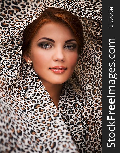 Beautiful girl face in leopard kerchief background. Beautiful girl face in leopard kerchief background