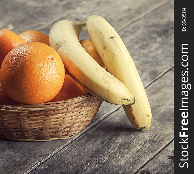 Basket of fruits on rustic, textured table. Basket of fruits on rustic, textured table