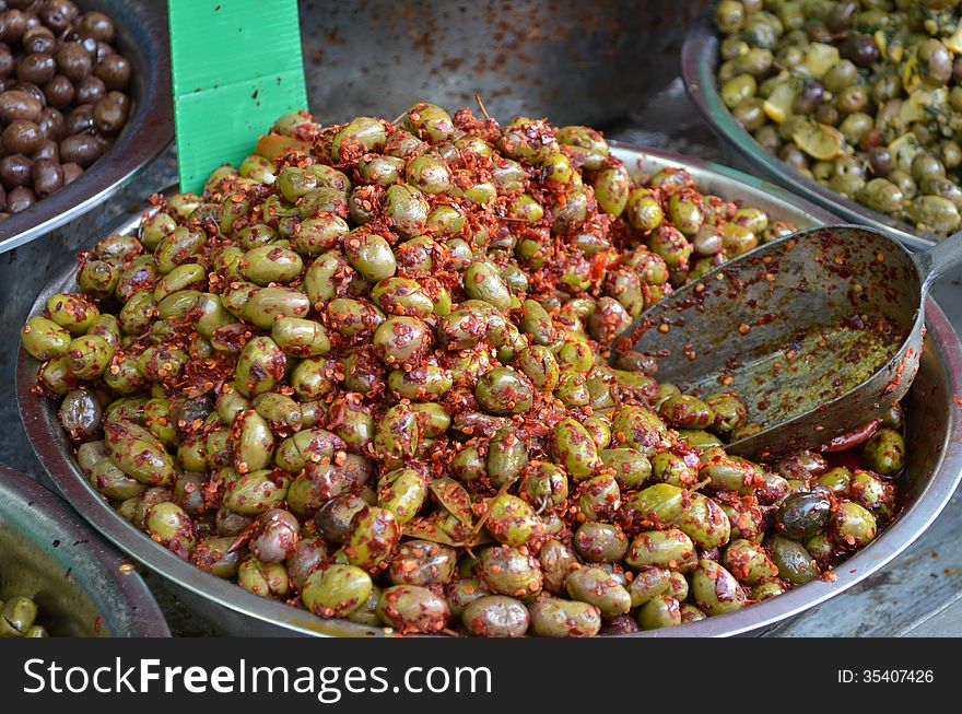 Close up of green olives with red pepper