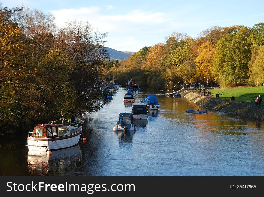 Autumn trees and boats on the edge of Loch Lomond, Scotland