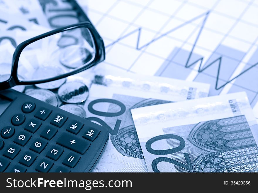 Profit concept. Eyeglasses and calculator on euro currency background with business chart. Profit concept. Eyeglasses and calculator on euro currency background with business chart