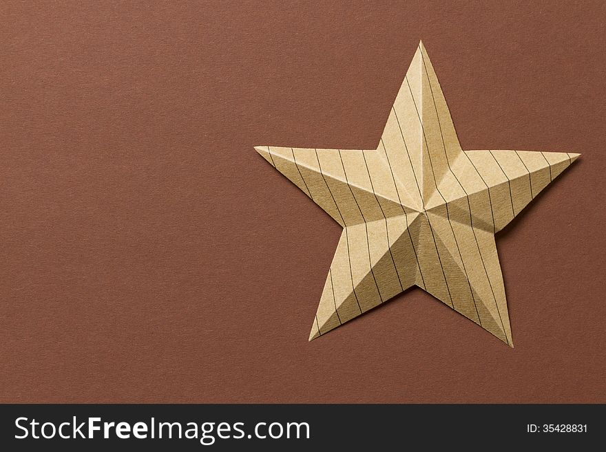 Paper origami star laying on colorful background