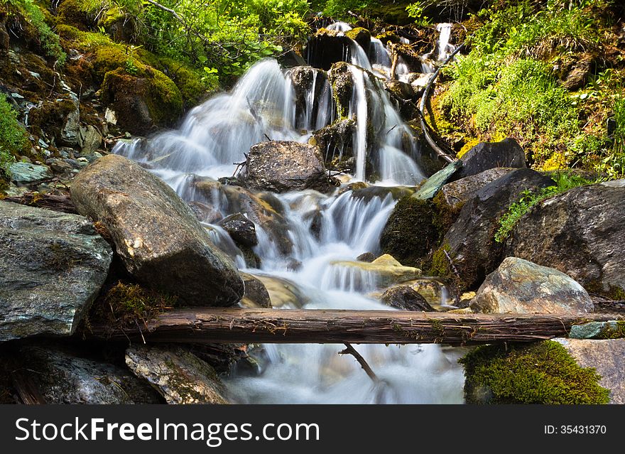 Waterfall in the Alps. Streams of water among the stones