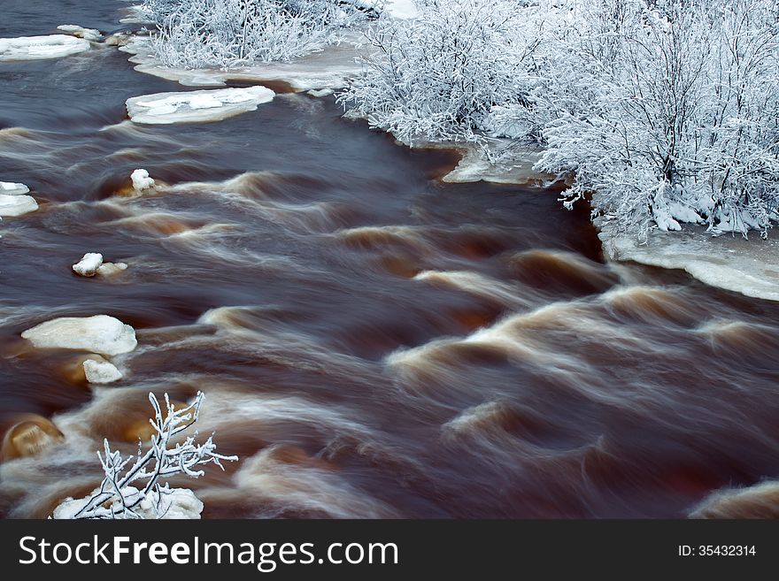 Water flow and bank of the river in winter forenoon