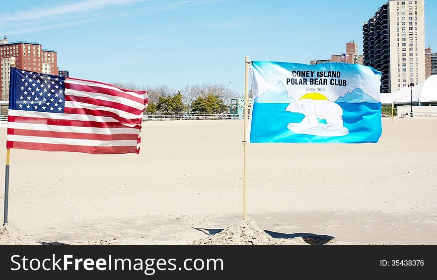 Two flags on the beach of Coney island ,on December ,flag of USA and flag of Polar bear club of swimmers who likes cold winter water of ocean. Two flags on the beach of Coney island ,on December ,flag of USA and flag of Polar bear club of swimmers who likes cold winter water of ocean