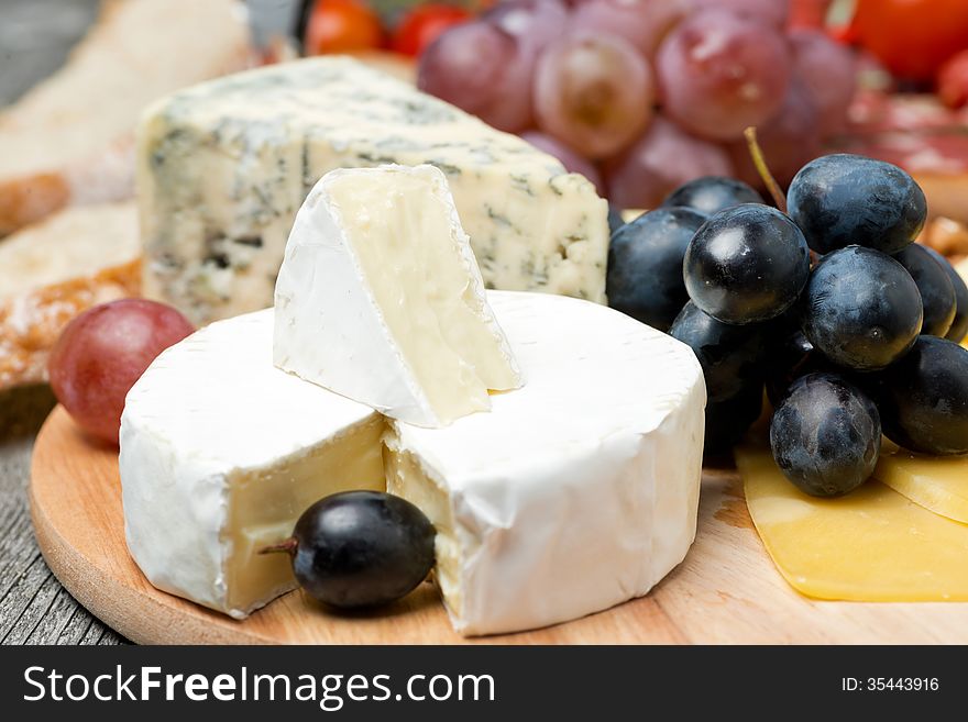 Camembert, blue cheese, grapes and walnuts, close-up