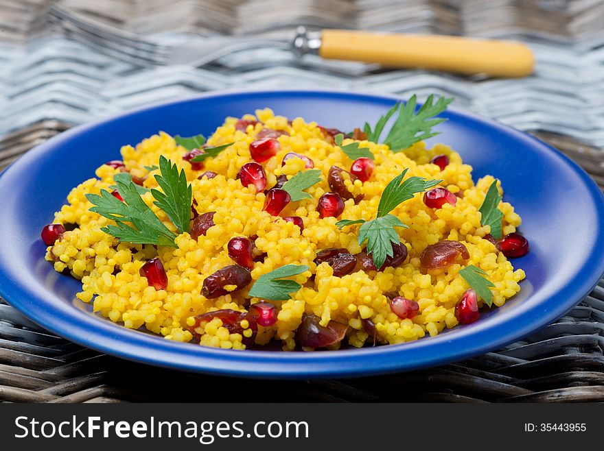 Couscous salad with curry, cranberries and herbs, close-up