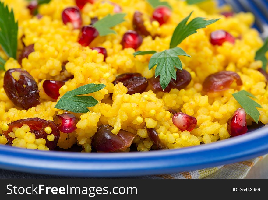 Couscous with curry, dried cranberries and herb, selective focus