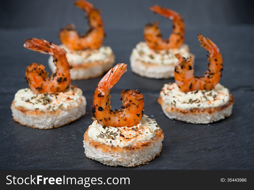 Festive appetizer with spicy shrimps on toast, horizontal