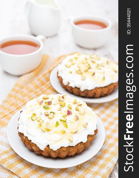 Mini carrot cakes with cream of mascarpone and honey on the white table