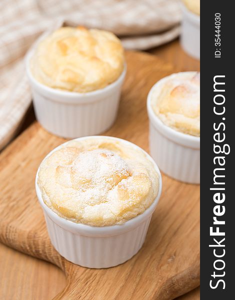 Peach souffle in the portioned form on a wooden board, vertical close-up