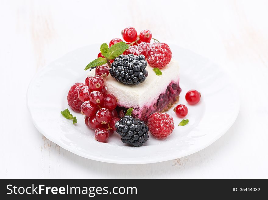 Piece of cake with fresh berries on the plate, close-up