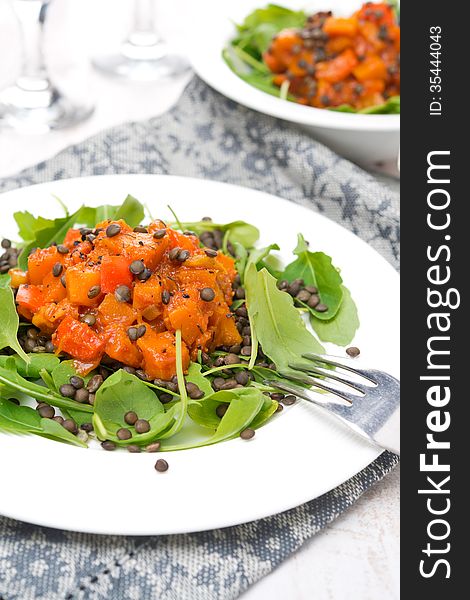 Salad with arugula, black lentils and vegetable stew, close-up