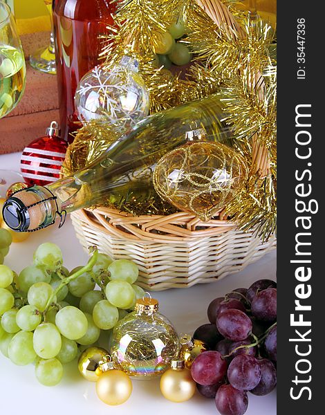 Bottle of white wine with grapes and Christmas decorations on white background. Bottle of white wine with grapes and Christmas decorations on white background