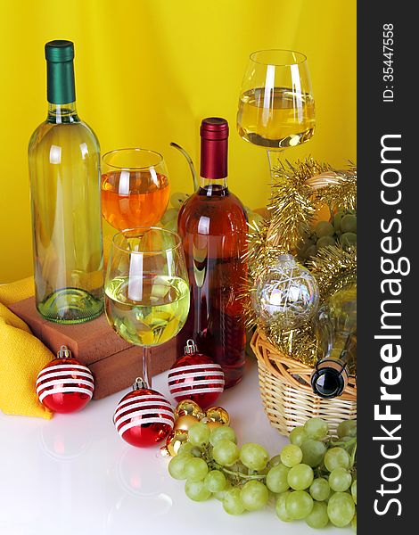 Bottles of wine with grapes and Christmas decorations on white background