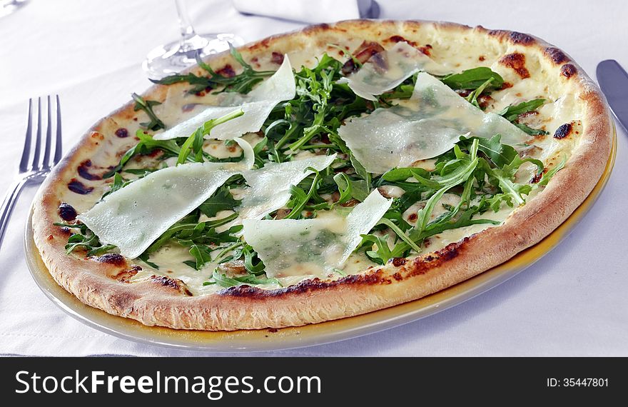 Pizza with mushrooms and parmesan cheese on a table in a restaurant