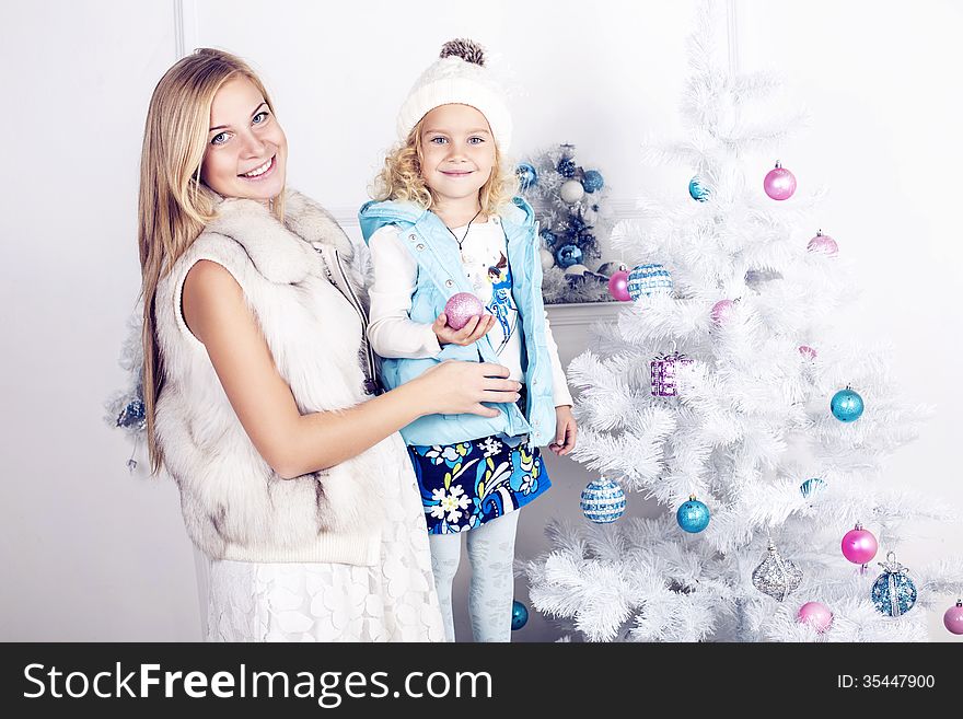 Little girl and her mother decorate Christmas tree. Little girl and her mother decorate Christmas tree