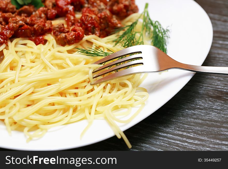 Closeup of plate with pasta Bolognese and fork