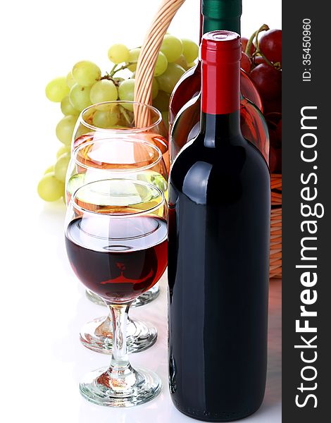 Bottles of wine with basket full of grapes on white background. Bottles of wine with basket full of grapes on white background