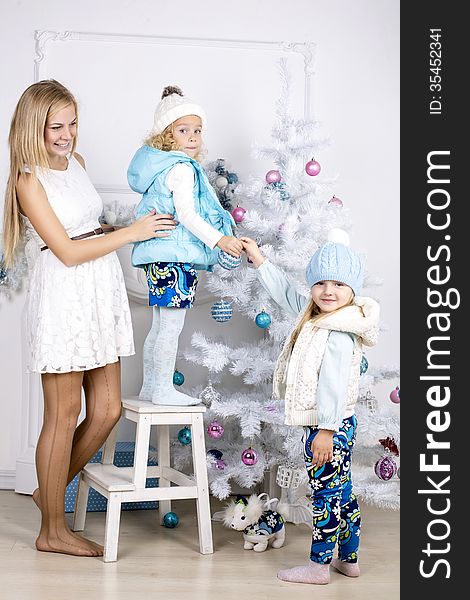 Little girls with mothers decorate Christmas tree. Little girls with mothers decorate Christmas tree