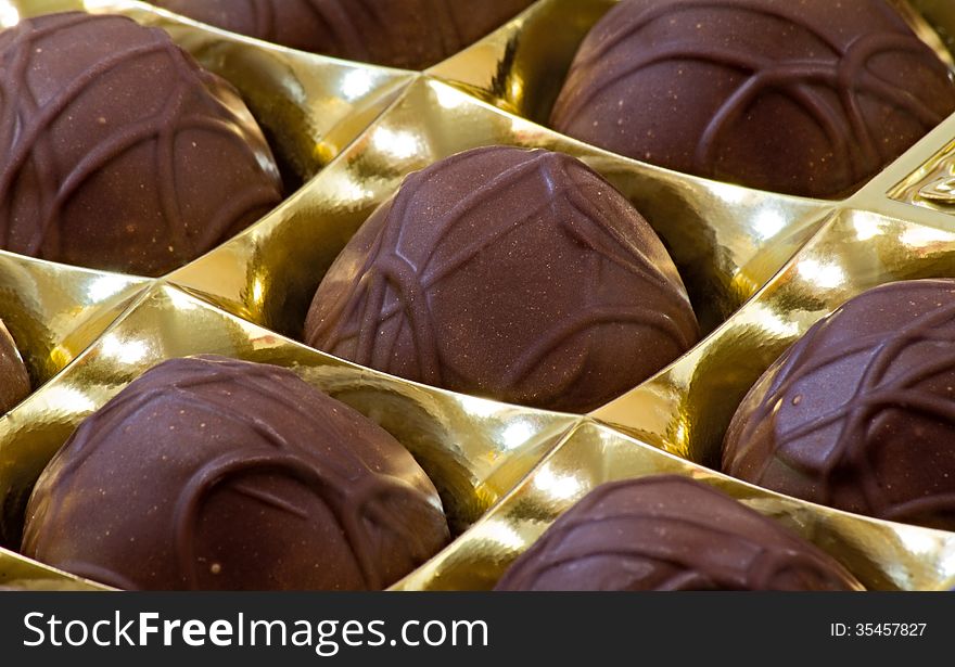 Chocolate sweets in the box on the white background.