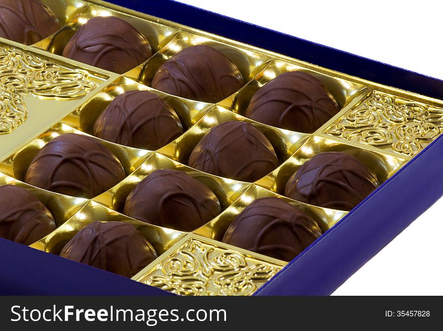 Fragment of the open blue boxes of chocolates. Presented on a white background. Fragment of the open blue boxes of chocolates. Presented on a white background